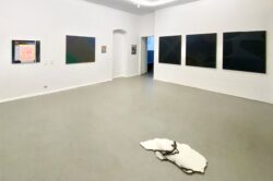 Paintings and scuptures in a white art space.